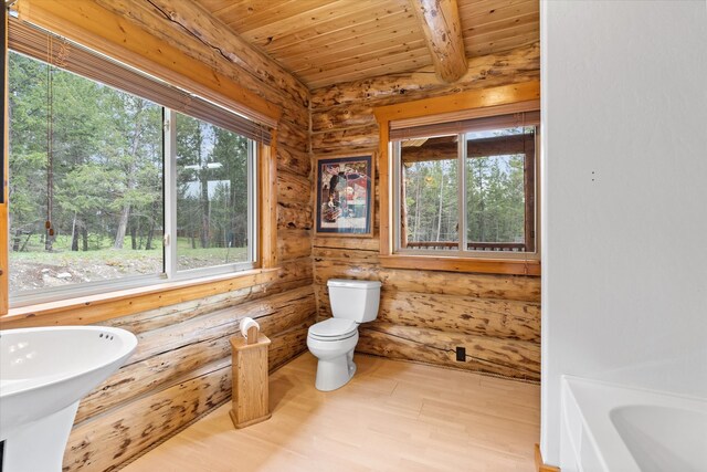 bathroom with toilet, wooden ceiling, plenty of natural light, and log walls