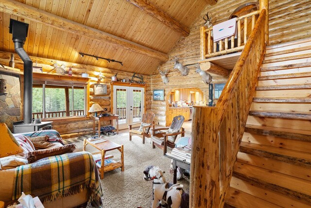 living area featuring french doors, log walls, stairway, wood ceiling, and a wood stove