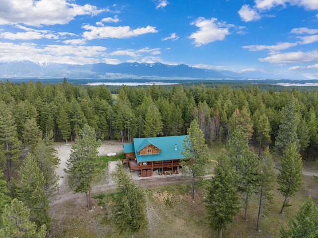 rear view of property with a garage, dirt driveway, log exterior, metal roof, and a deck