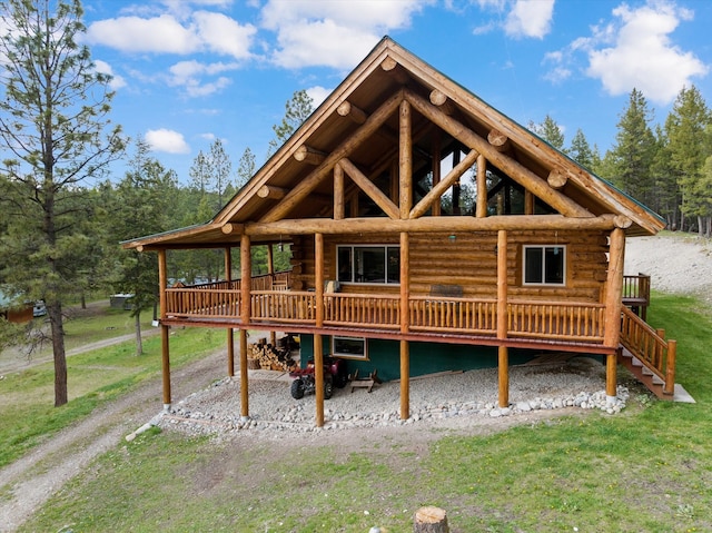 rear view of property with a lawn, a deck, and log siding