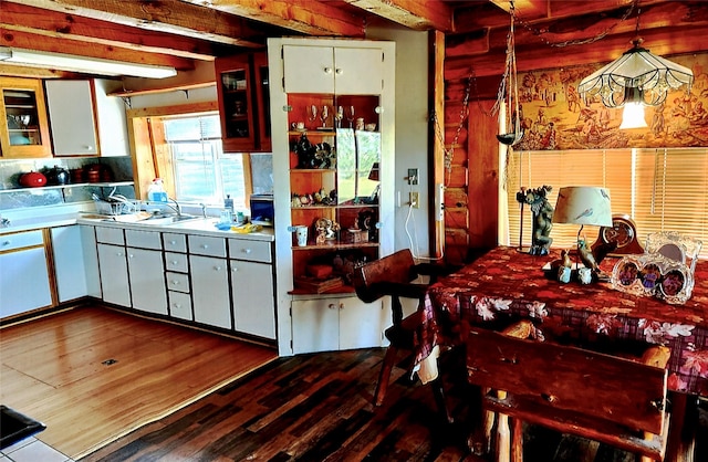 630 18th Rd NW, Choteau, MT 59422 - kitchen with dark wood finished floors, white cabinets, light countertops, a sink, and beam ceiling