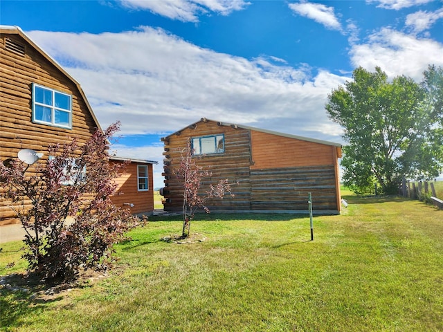 630 18th Rd NW, Choteau, MT 59422 - view of side of property featuring a yard, log siding, and an outbuilding