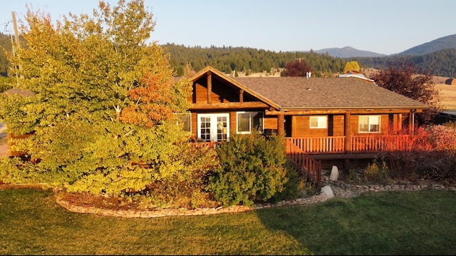 back of house featuring a deck with mountain view and a yard