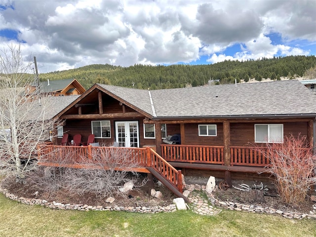 102 W Clark St, Philipsburg, MT 59858 - back of property featuring a forest view, a shingled roof, french doors, and a deck