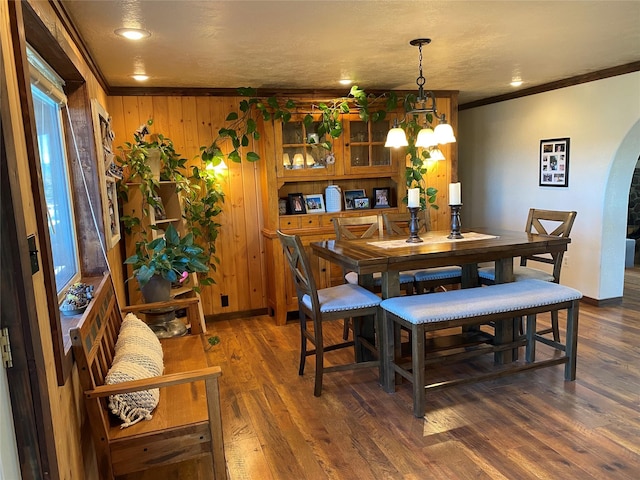 102 W Clark St, Philipsburg, MT 59858 - dining area featuring wooden walls, wood finished floors, arched walkways, crown molding, and baseboards