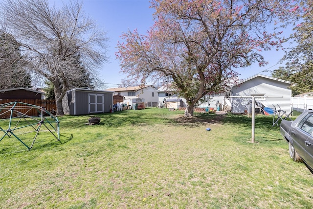 view of yard featuring a shed, an outdoor structure, and fence