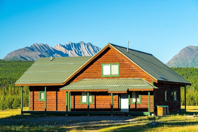 400 Kintla Ranch Rd, Polebridge, MT 59928 - view of front facade with a mountain view, covered porch, a metal roof, and a front yard