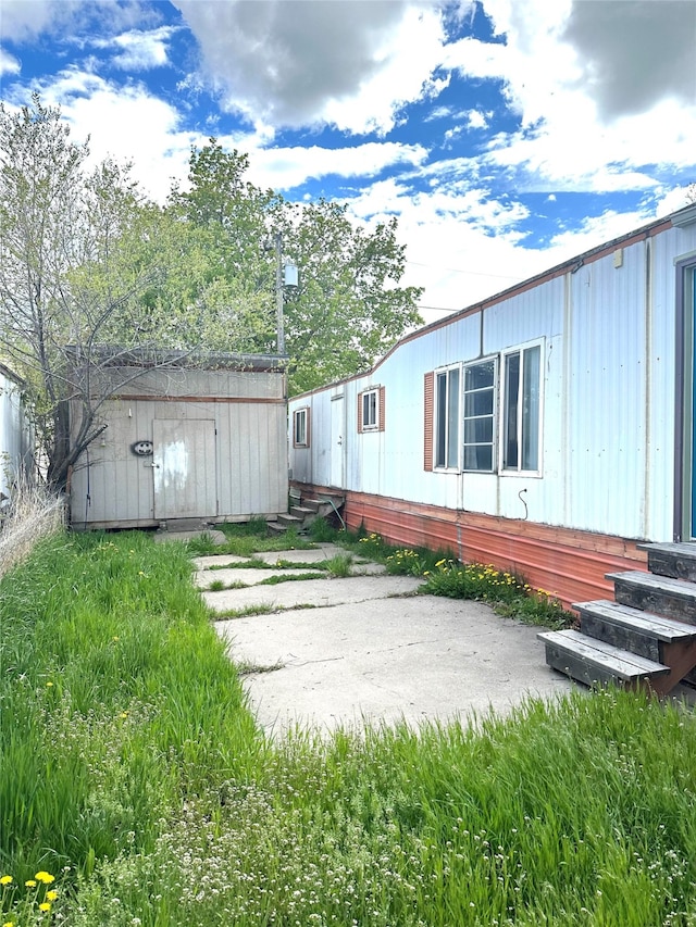 view of yard featuring a patio and an outdoor structure