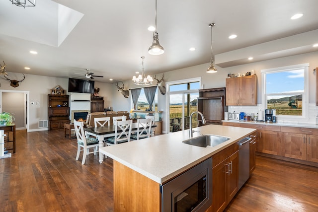 kitchen featuring a center island with sink, sink, a healthy amount of sunlight, and stainless steel appliances