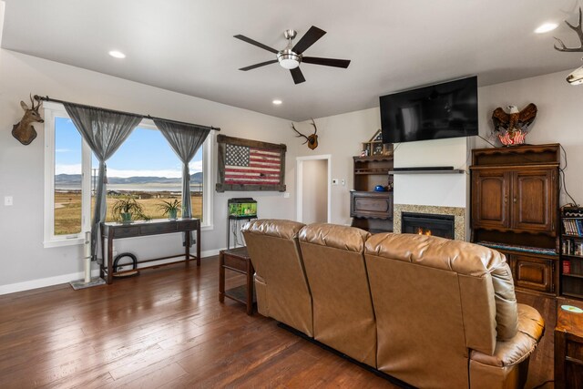 living room with ceiling fan and dark wood-type flooring