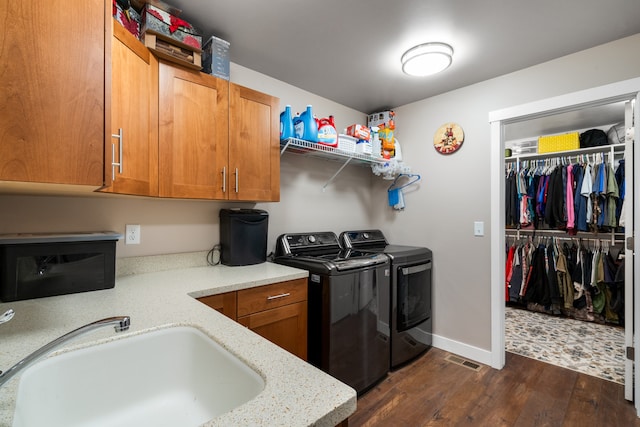 laundry room featuring dark hardwood / wood-style floors, independent washer and dryer, sink, and cabinets