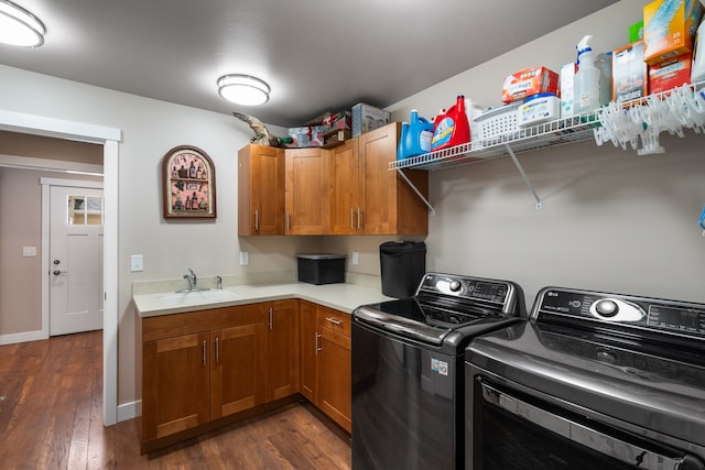 laundry area featuring cabinets, dark hardwood / wood-style floors, sink, and washing machine and clothes dryer