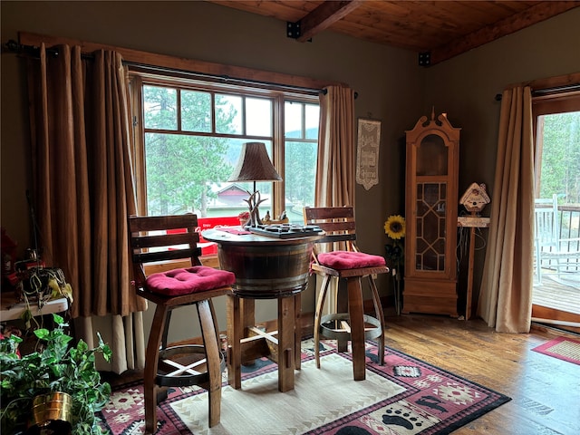 dining space with beamed ceiling, wood-type flooring, a wealth of natural light, and wood ceiling