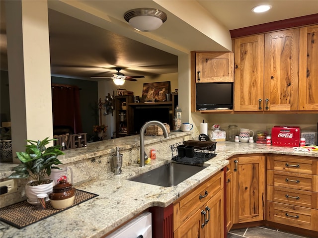 kitchen with sink, ceiling fan, tile floors, and light stone countertops