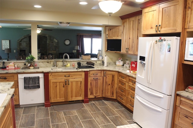 kitchen featuring ceiling fan, white appliances, sink, and light stone counters