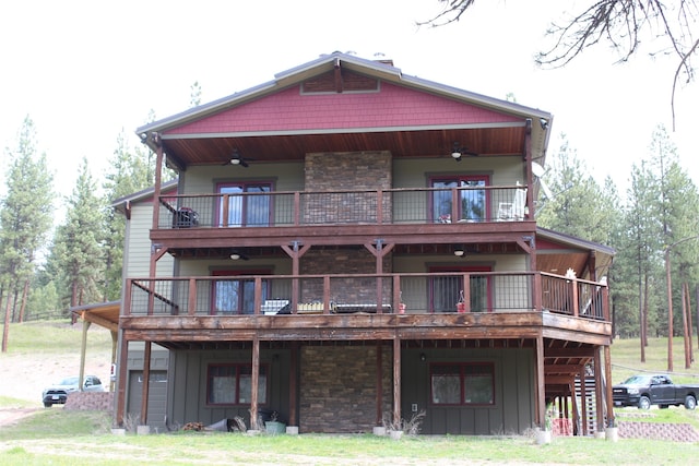 back of property with a balcony and ceiling fan