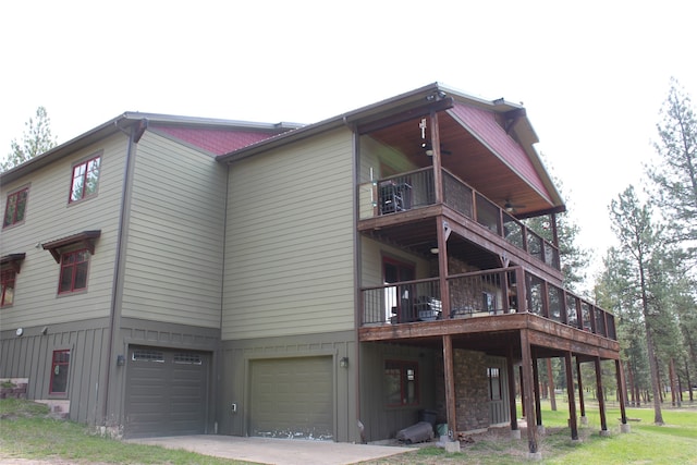 rear view of house with a garage and a balcony