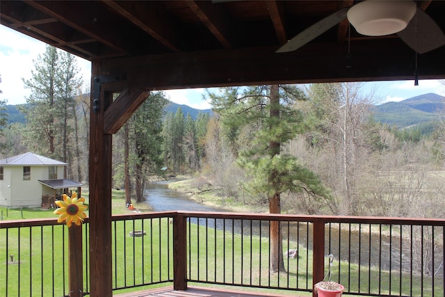 wooden terrace with a mountain view and a lawn