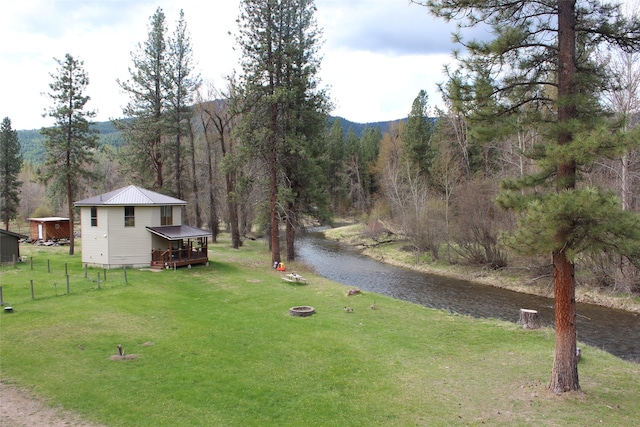 view of yard featuring an outdoor structure and a water view