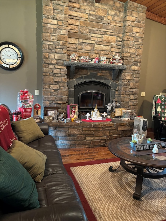 living room with hardwood / wood-style flooring and a stone fireplace