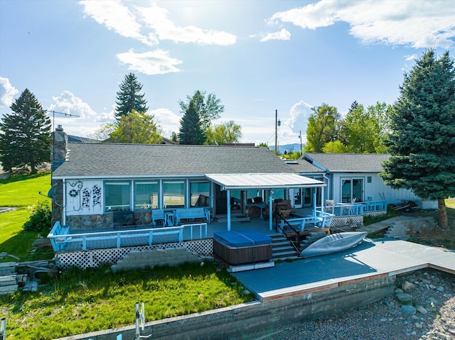 back of house featuring a wooden deck and a lawn