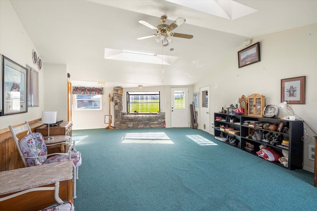 interior space featuring vaulted ceiling with skylight, ceiling fan, and carpet flooring