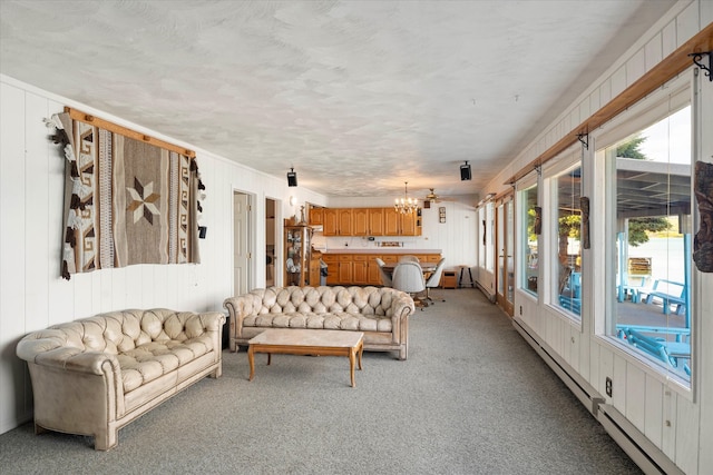 carpeted bedroom featuring baseboard heating, a chandelier, and a textured ceiling