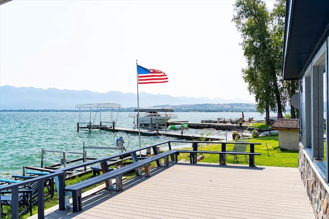 view of dock with a yard and a water and mountain view