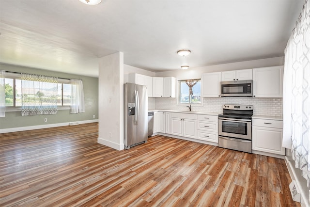 kitchen with white cabinetry, appliances with stainless steel finishes, and light wood-type flooring