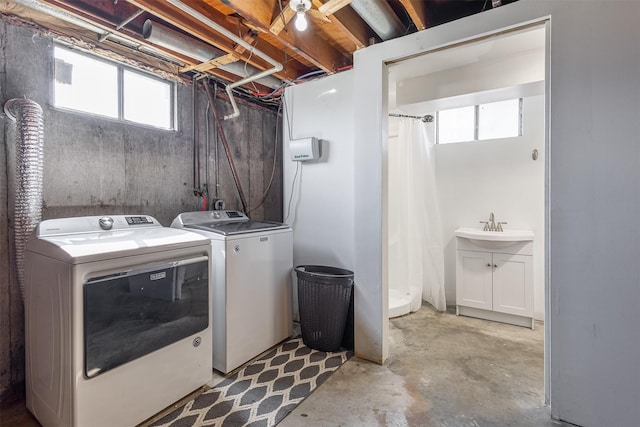 clothes washing area with washing machine and clothes dryer and sink