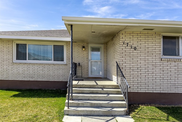 property entrance with a lawn