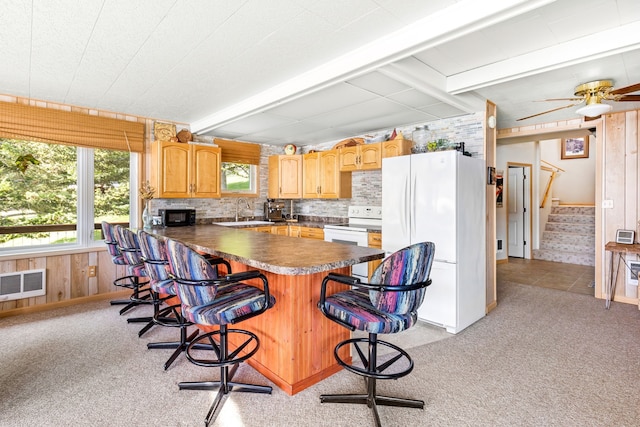 kitchen featuring ceiling fan, light colored carpet, beam ceiling, and white appliances