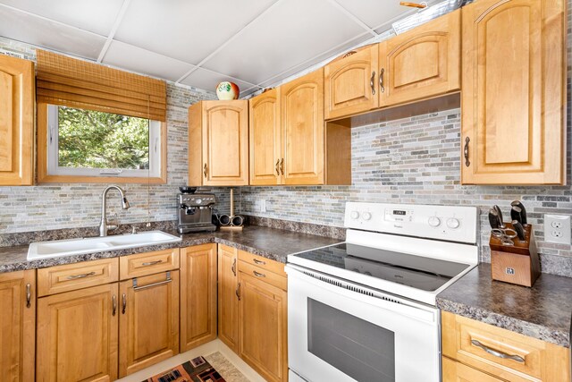 kitchen with backsplash, white range with electric cooktop, a paneled ceiling, and sink