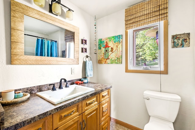 bathroom featuring toilet and vanity with extensive cabinet space