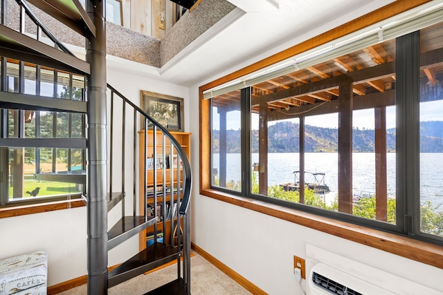 sunroom featuring a water and mountain view