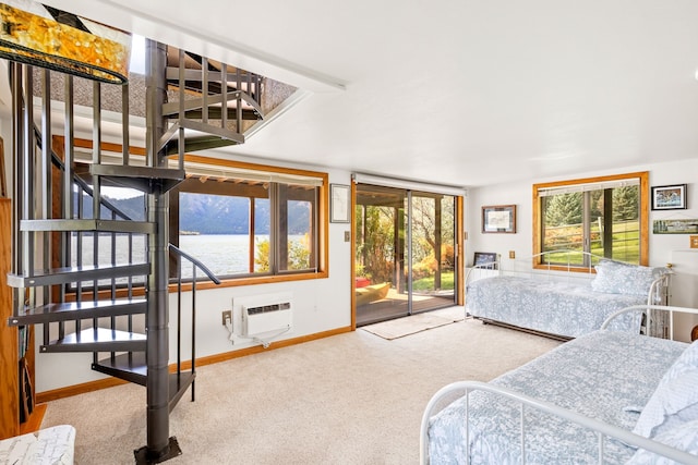 bedroom featuring a water view, a wall mounted AC, carpet, and access to outside