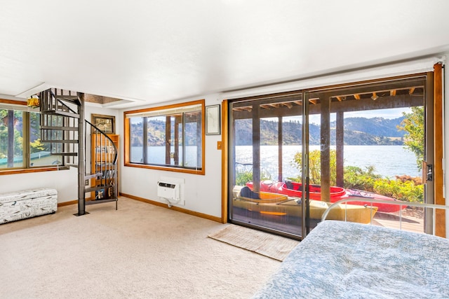 interior space with multiple windows, a wall mounted air conditioner, and a water and mountain view