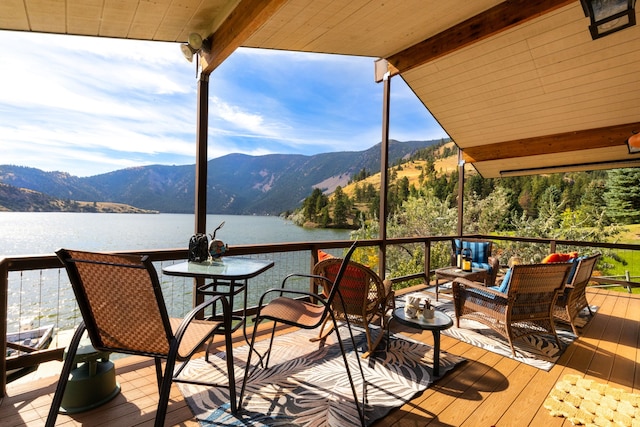 wooden deck with an outdoor living space and a water and mountain view