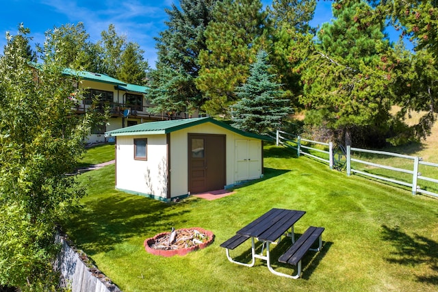 view of shed / structure featuring a yard and an outdoor fire pit