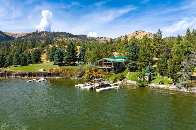 property view of water with a mountain view and a dock