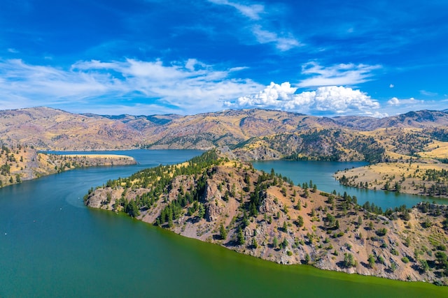 drone / aerial view featuring a water and mountain view