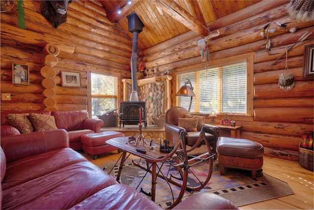 living room featuring beamed ceiling, a wood stove, wooden ceiling, and hardwood / wood-style floors