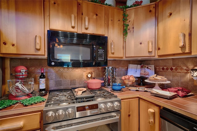 kitchen with tasteful backsplash, tile countertops, and stainless steel appliances