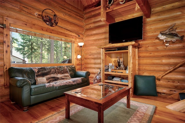 living area with hardwood / wood-style floors and rustic walls