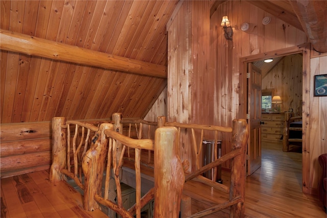 interior space featuring log walls, wood ceiling, wood walls, vaulted ceiling with beams, and hardwood / wood-style floors