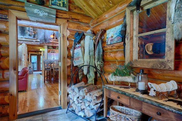 interior space featuring rustic walls, lofted ceiling, and wood ceiling