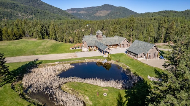 birds eye view of property featuring a forest view and a water and mountain view