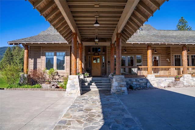 exterior space with a shingled roof and a porch