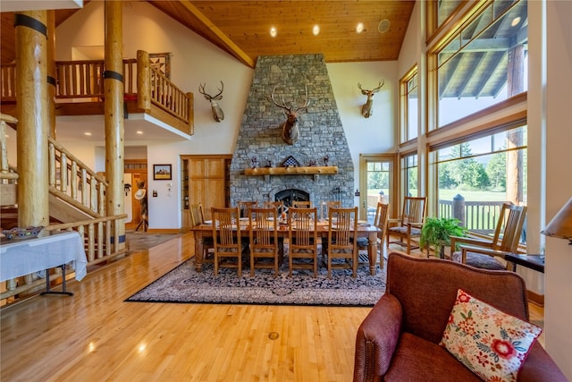 dining area with stairs, high vaulted ceiling, wooden ceiling, and wood finished floors