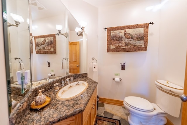 bathroom with toilet, tile patterned floors, vanity, and baseboards